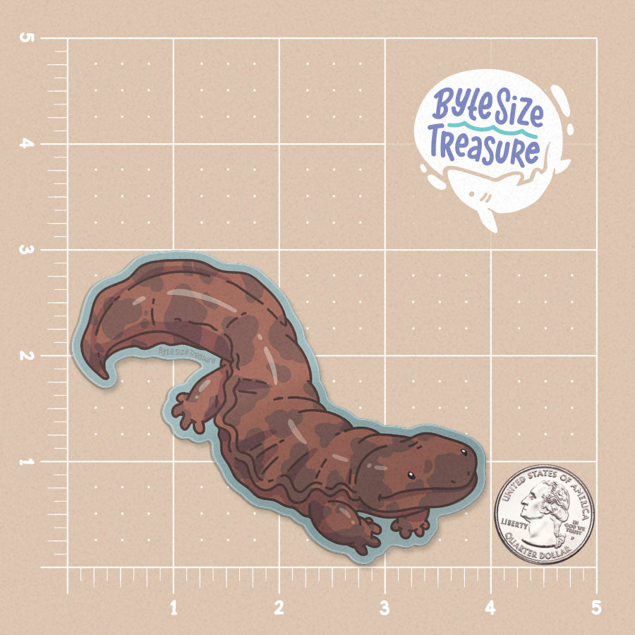 A brown salamander sticker - shown on a tan measuring grid background with a quarter for scale. Art by Byte Size Treasure