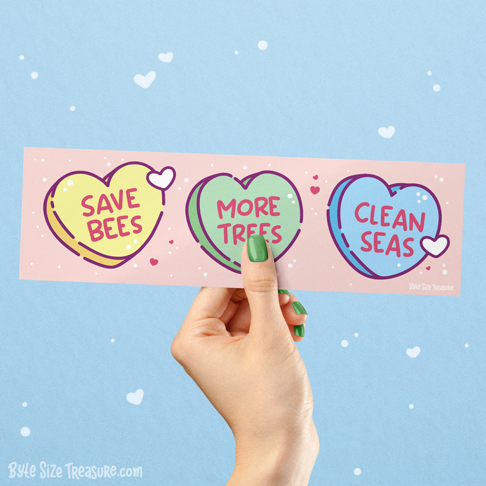 Hand holding a pink bumper sticker with heart-shaped messages &