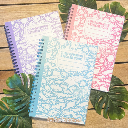 Three spiral-bound "composition" sticker books with fish as the shapes of the pattern instead of little blobs and the title block of each books CompoFISHion Sticker Book. The books are available in 3 colors - lavender, teal, and pink, and are shown arranged on a wooden surface with green tropical leaves. 