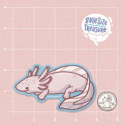 A leucistic pink axolotl sticker - shown on a pink measuring grid background with a quarter for scale. Art by Byte Size Treasure